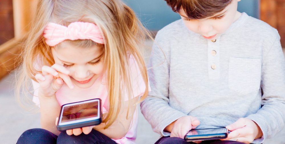 Kinder spielen mit einem Handy