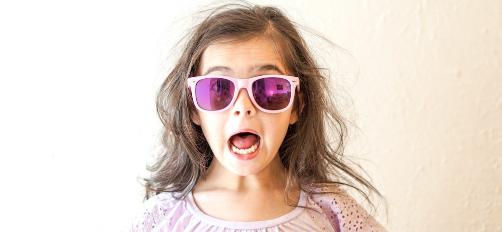 Kind mit aufgerissenen Augen und Mund und Sonnenbrille